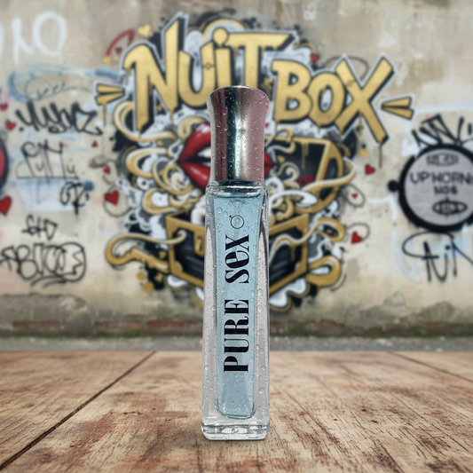 Perfume Pure Sex sobre mesa de madera, mural Nuit Box y grafitis al fondo, sex shop online.