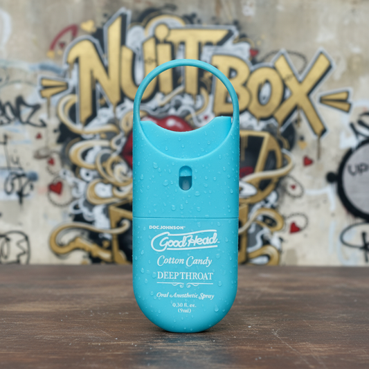 Spray oral GoodHead Cotton Candy sobre mesa, fondo grafiti Nuit Box, sex shop en Chile.